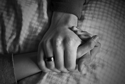 black and white photo of two people with hands clasped - how to help an addict you care about - no more enabling - nomoreenabling.com