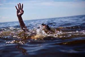 photo of a man drowning with a hand reaching out of the water - powerlessness